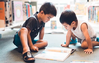 Kiwi kids reading a book at childcare